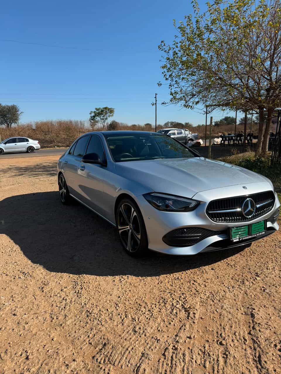 Front three-quarter view of the Mercedes against a deep blue sky